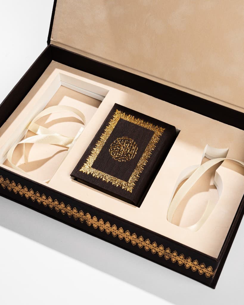 Open luxury gift box with gold foil detailing and presentation ribbons