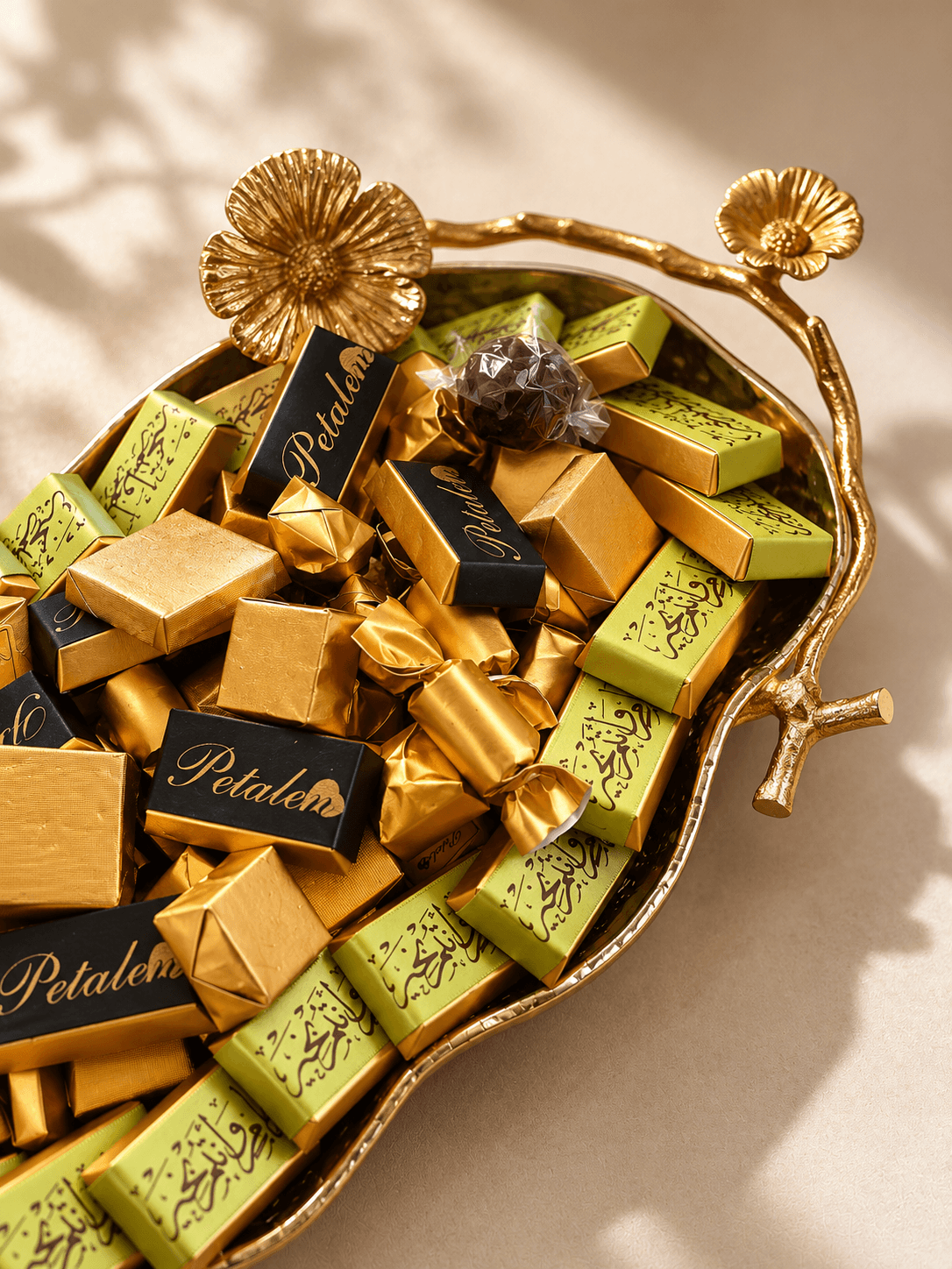Petalen branded gold chocolates arranged in a decorative golden tray