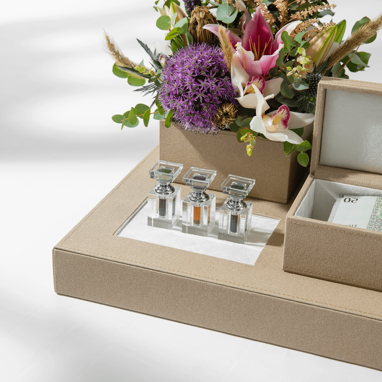 Beige Vow platform with perfume bottles and floral arrangement