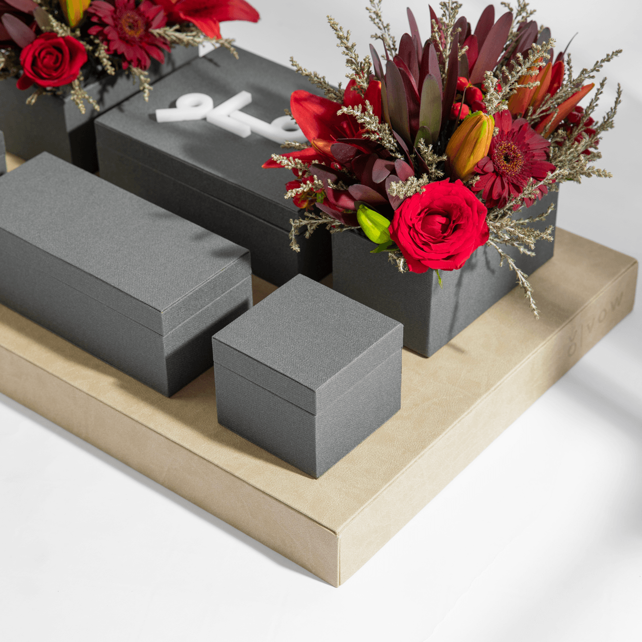 Grey Vow box collection in varying sizes with deep red floral arrangements