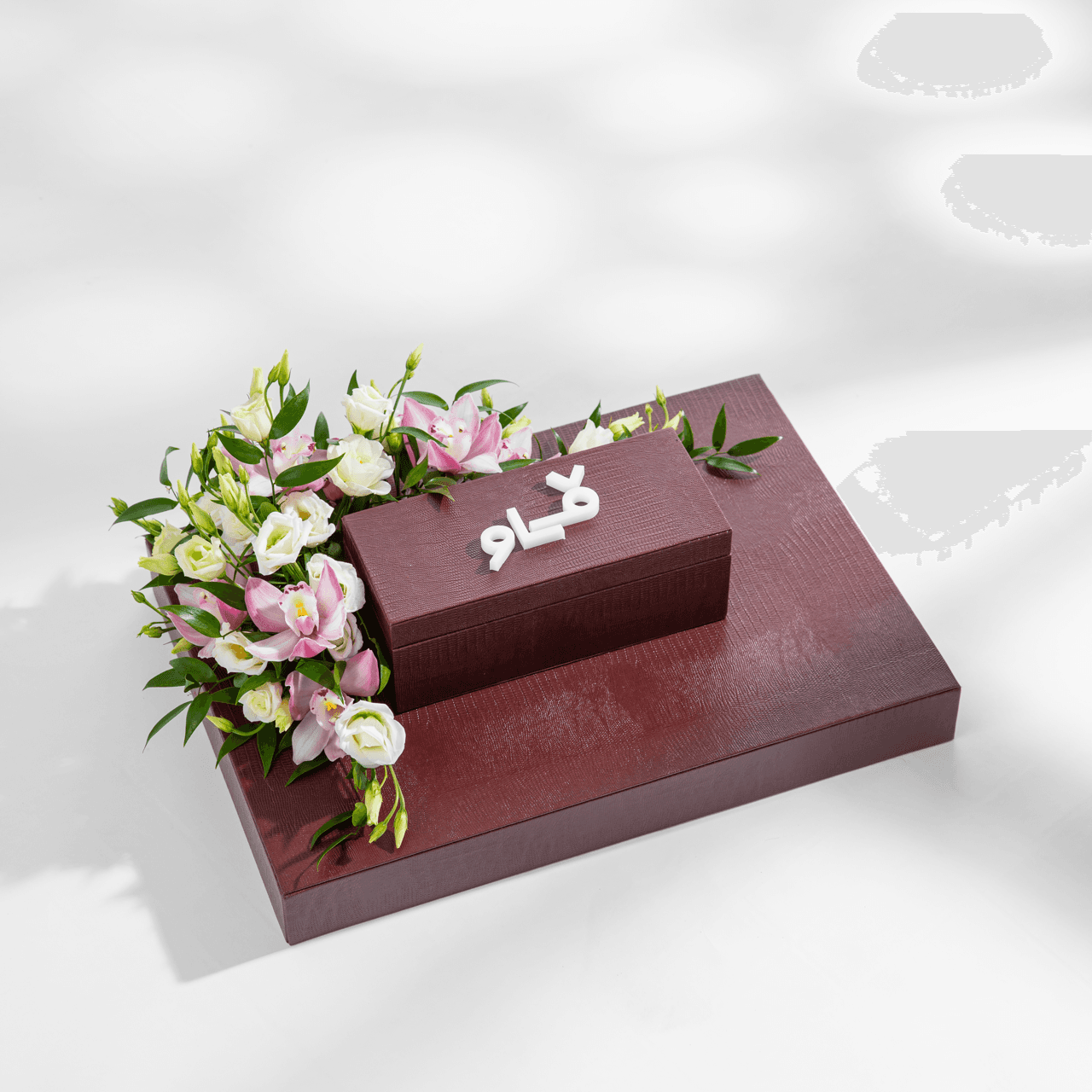 Burgundy Vow presentation box with white Arabic lettering and pink orchids