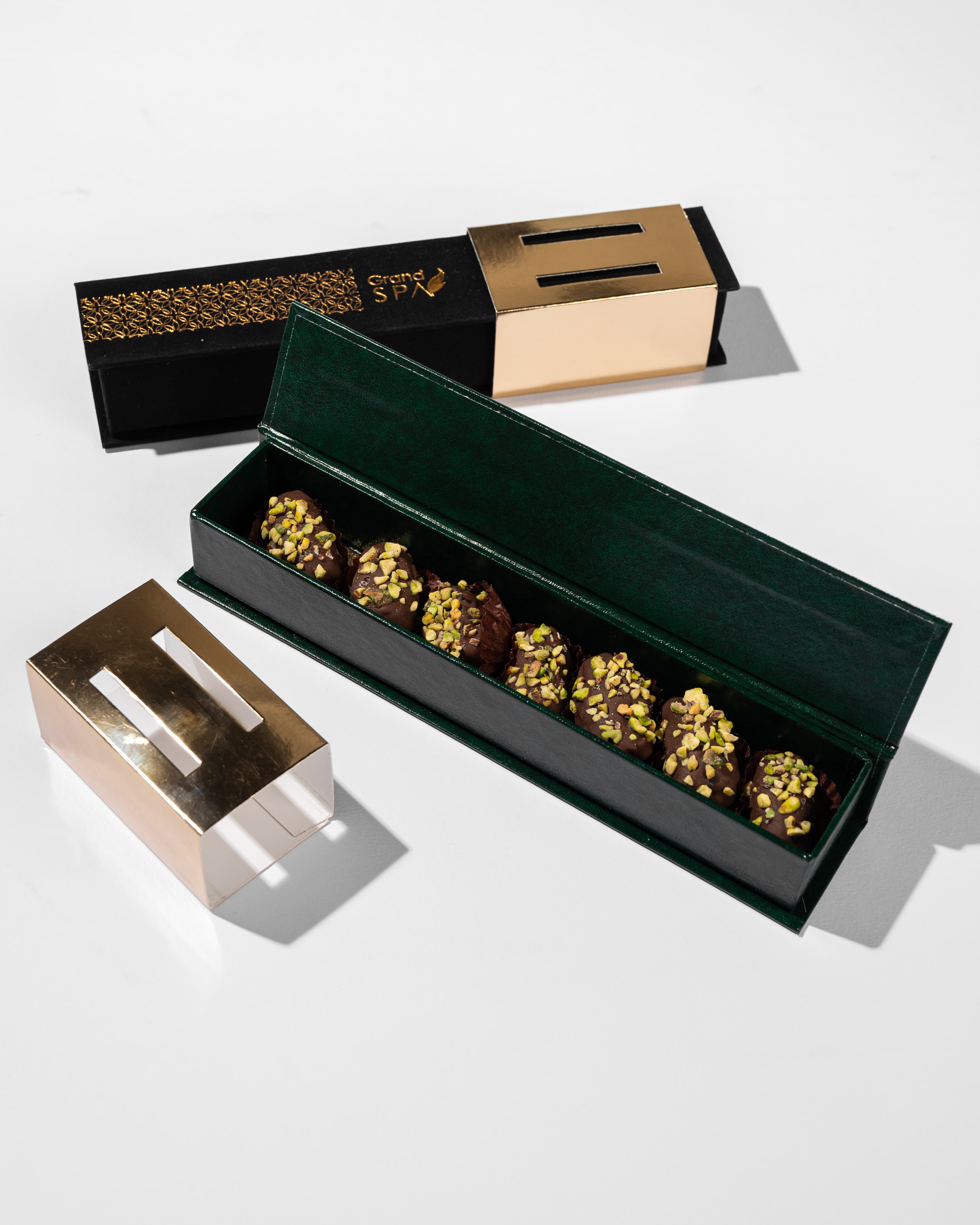 Grand Spa green leather chocolate box open to reveal pistachio truffles